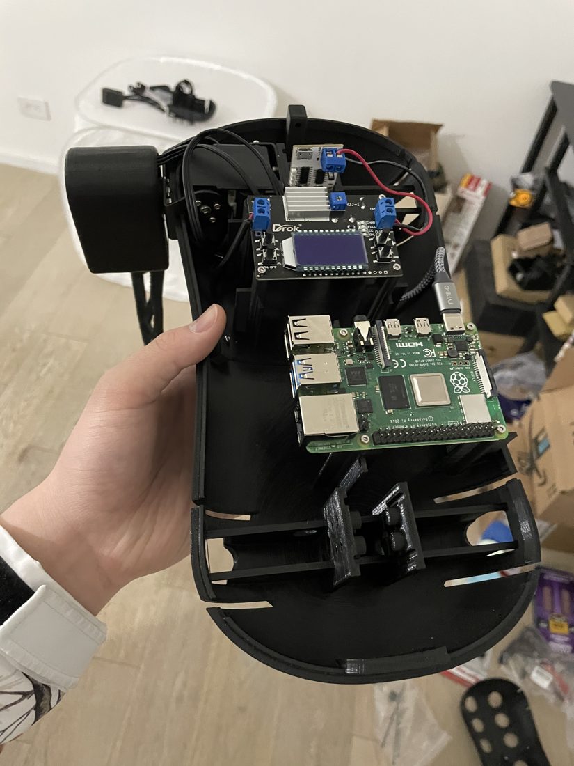 Assembled quadruped held in hand, Raspberry Pi and electronics mounted in the printed body