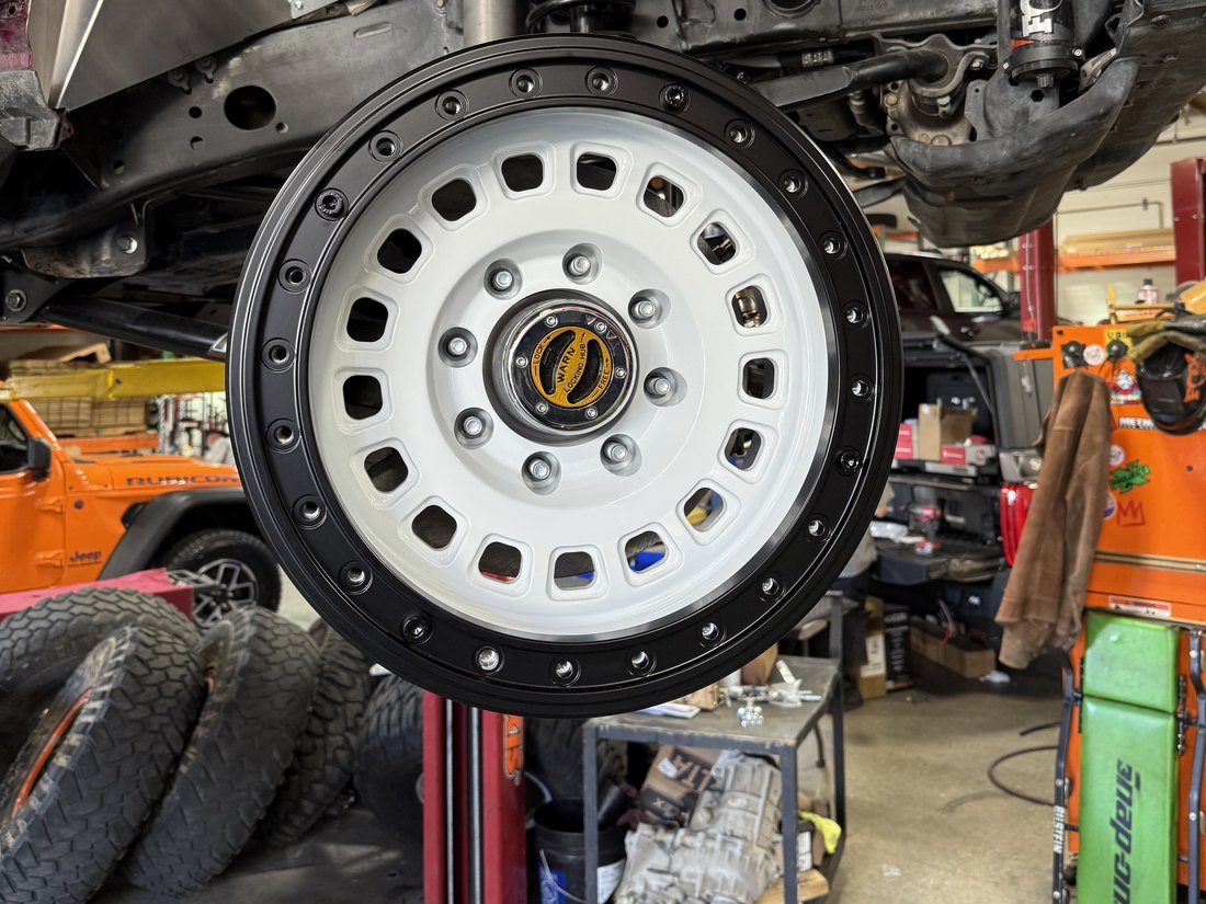 The finished white forged wheel mounted on the Jeep, true beadlock ring visible